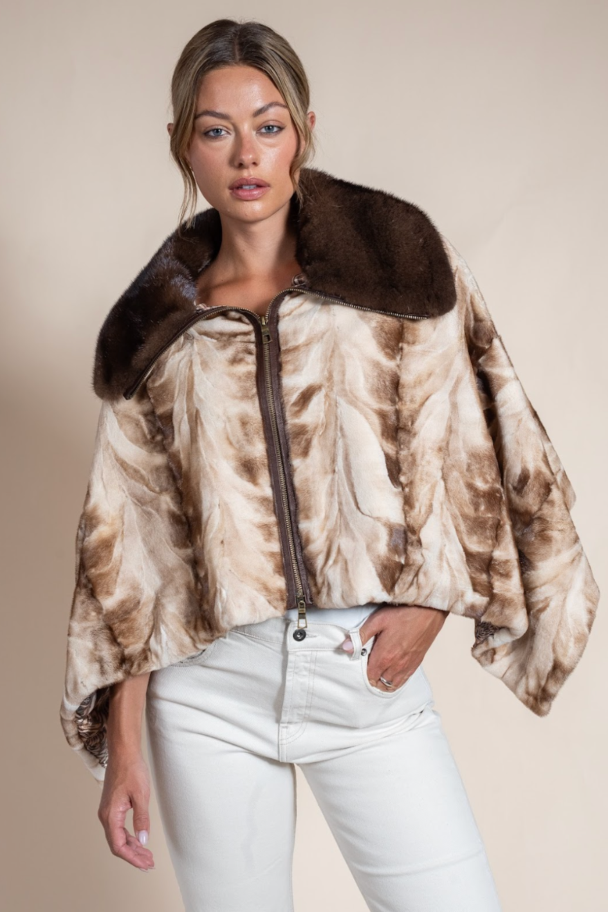 Woman wearing a patterned jacket with a fur collar on a beige background