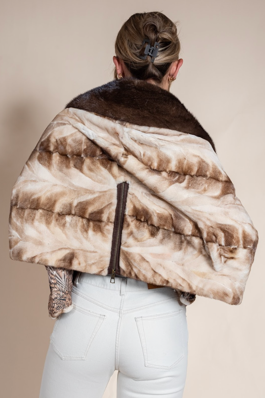 Person wearing a patterned fur coat with a neutral background