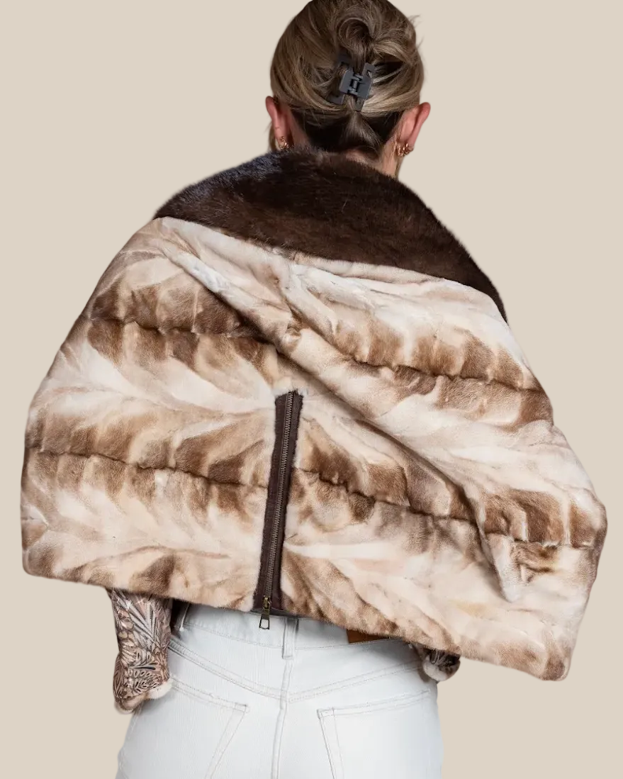 Person wearing a patterned fur coat with a neutral background