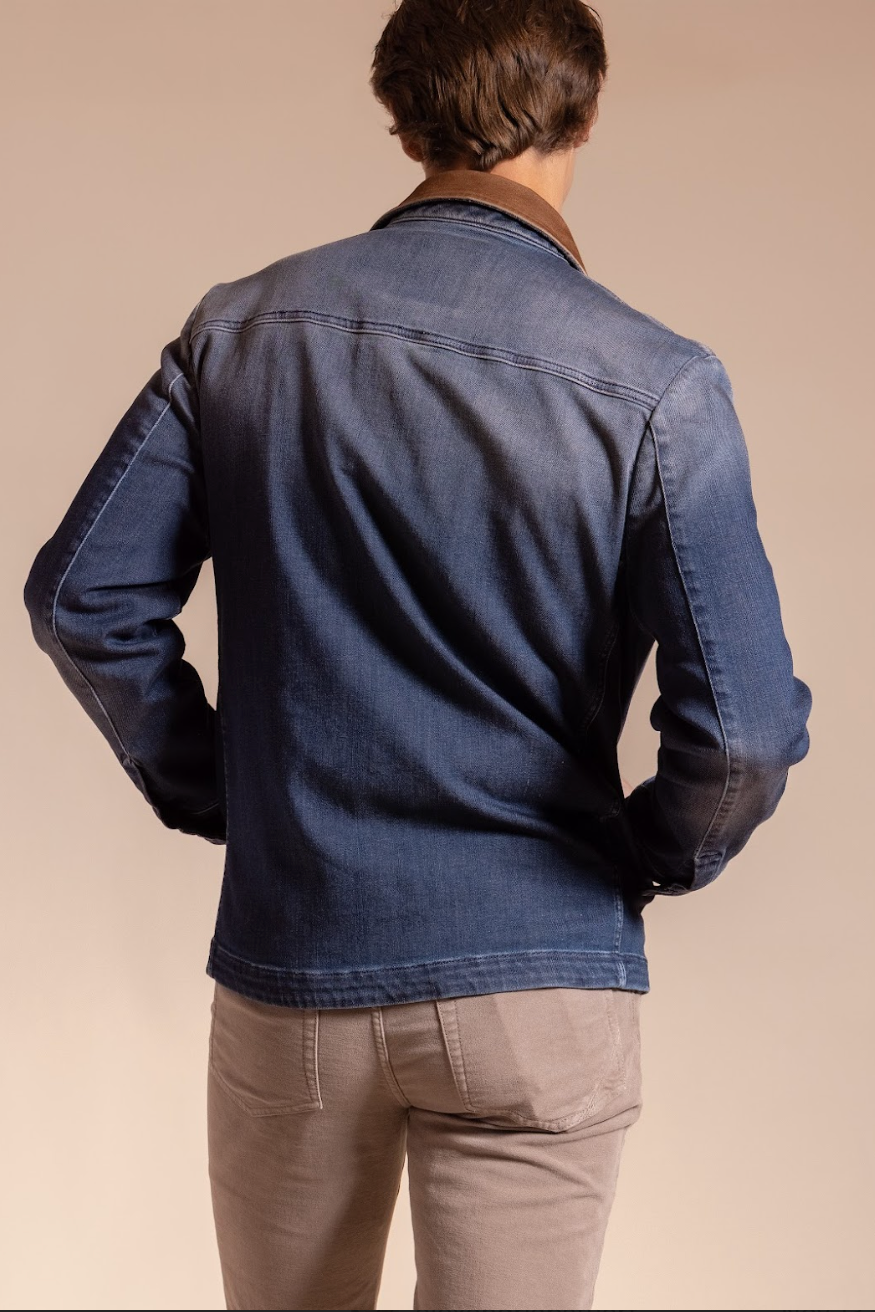 Person wearing a blue denim jacket on a beige background
