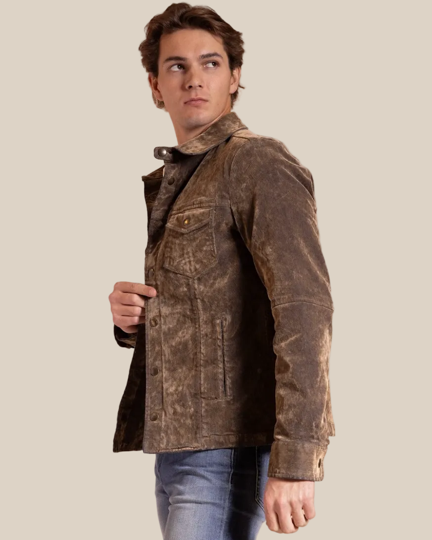 Person wearing a brown jacket and blue jeans on a beige background