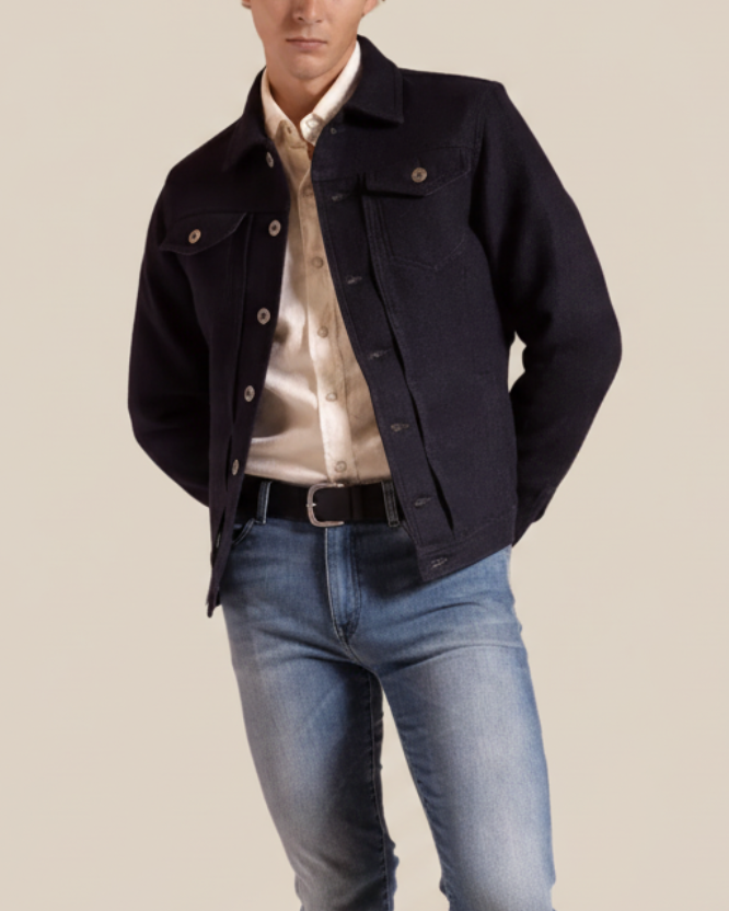 Man wearing a dark denim jacket over a light shirt and jeans on a beige background