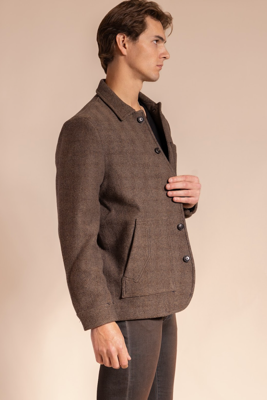 Man wearing a brown suit jacket on a beige background