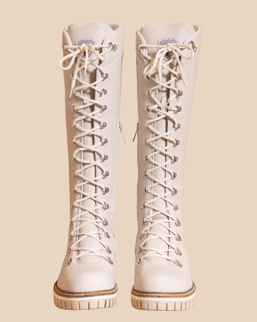 Pair of white lace-up boots on a beige background