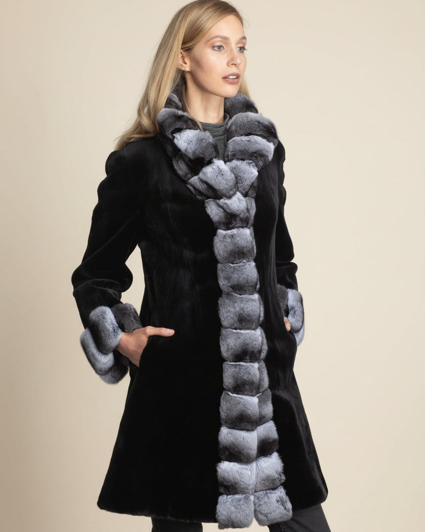 Woman wearing a black coat with gray fur trim on a beige background