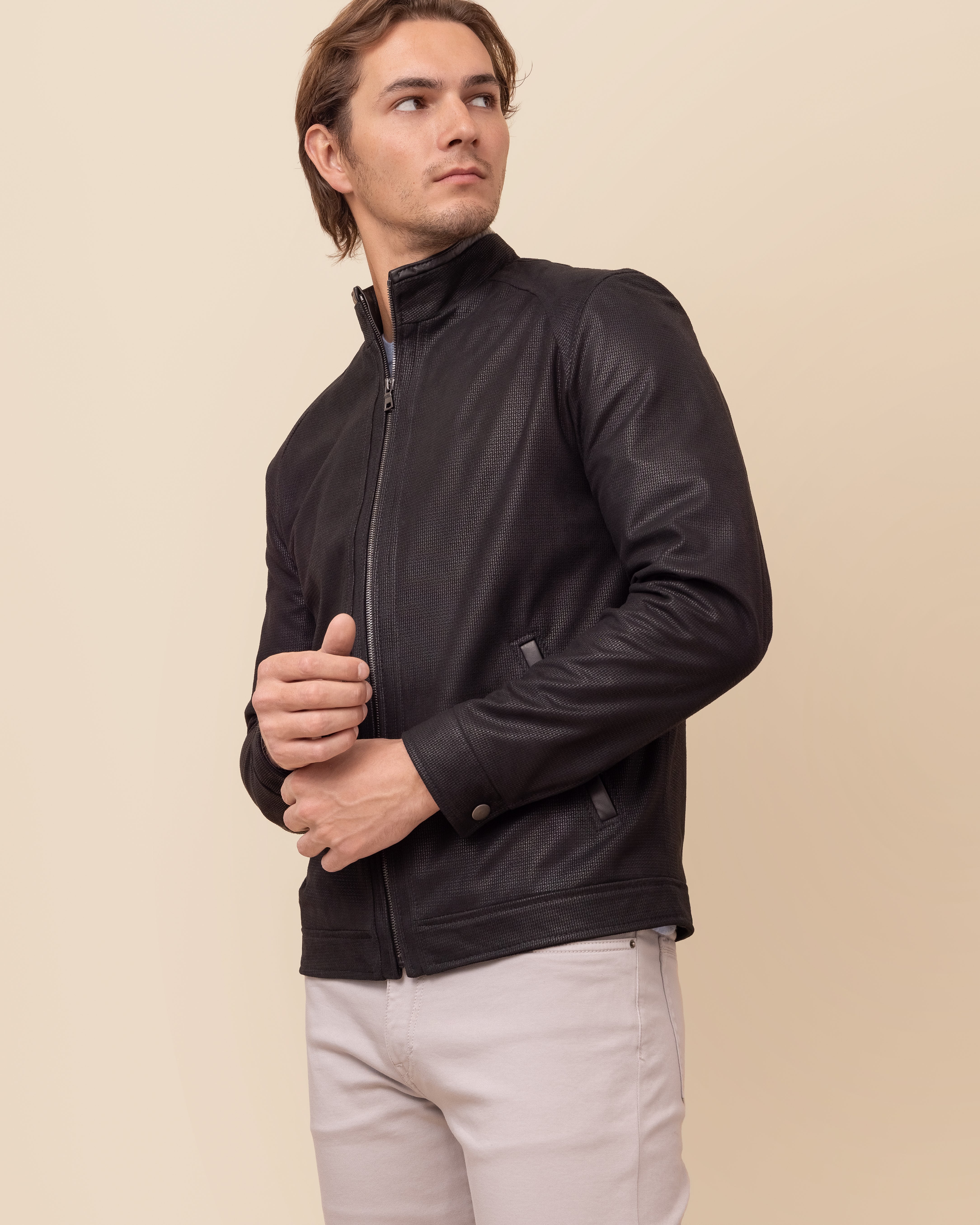 HYDE Obsidian Noir — three-quarter view showing welt hand pockets and stand collar, NuBuck Print embossed lambskin leather