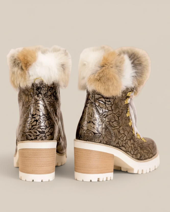 Pair of metallic boots with fur trim on a white background