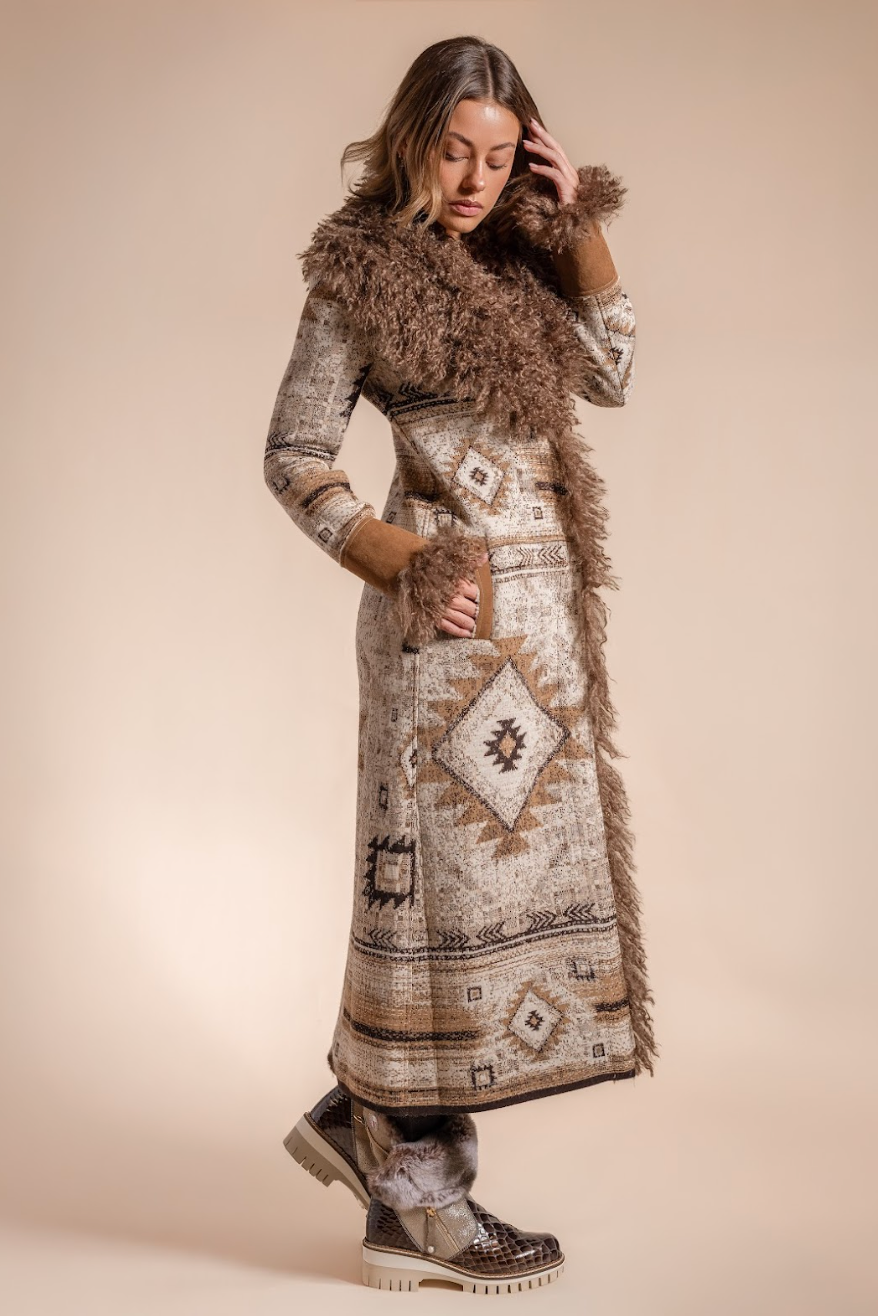 Woman wearing a long, patterned coat with fur trim on a beige background