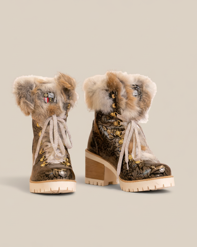 Pair of camouflage boots with fur trim on a white background