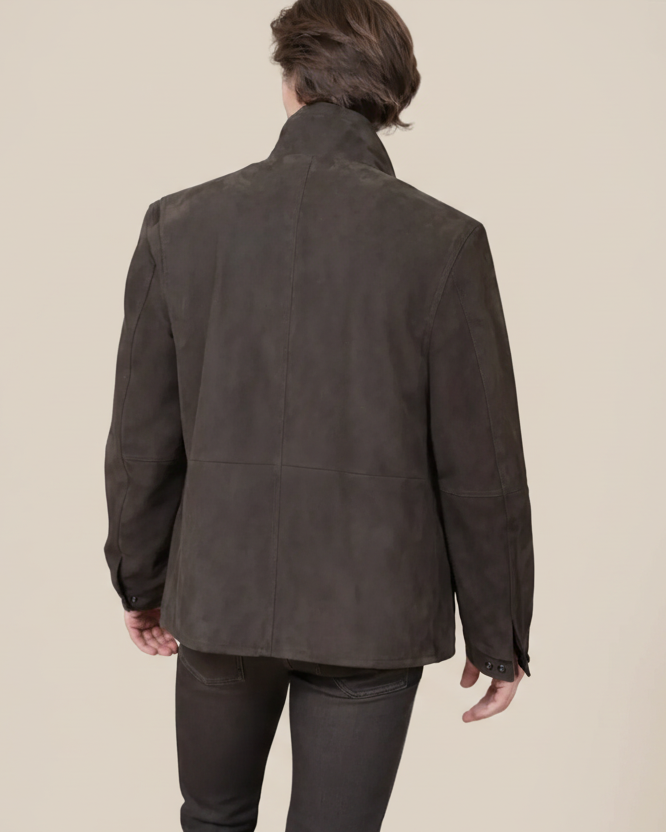 Person wearing a dark brown jacket on a beige background