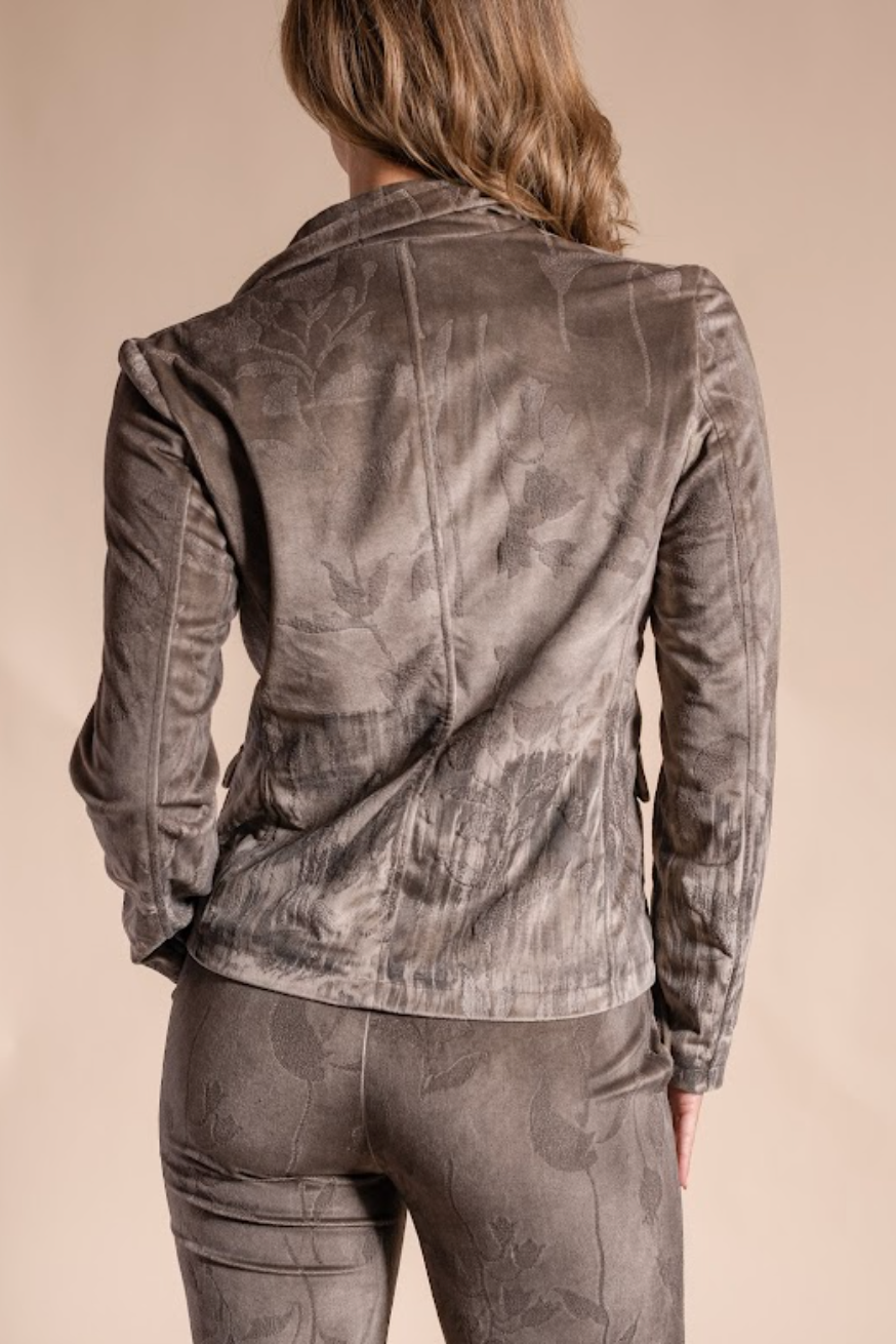 Person wearing a camouflage-patterned jacket and pants on a beige background