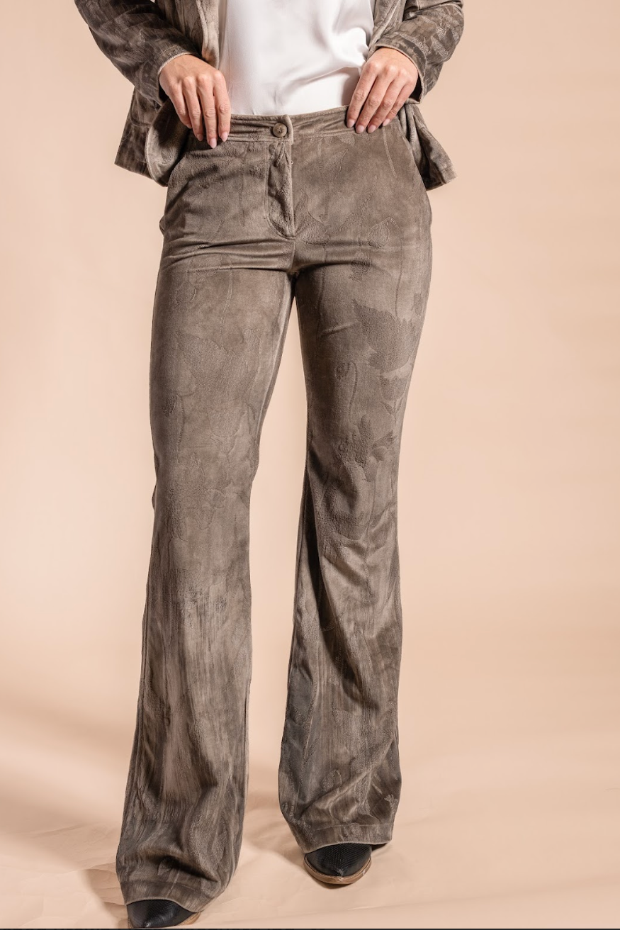 Person wearing brown corduroy pants on a beige background