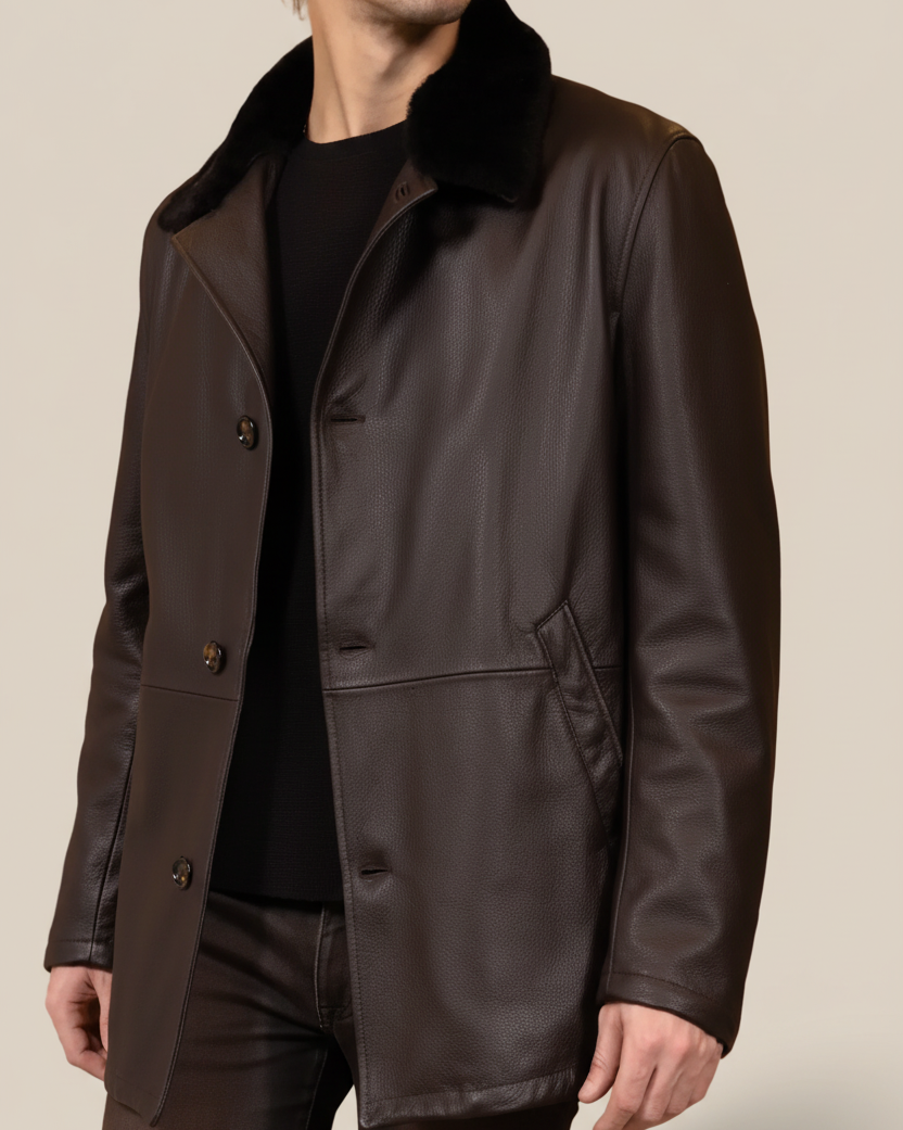 Man wearing a dark brown leather coat with a fur collar on a brown background