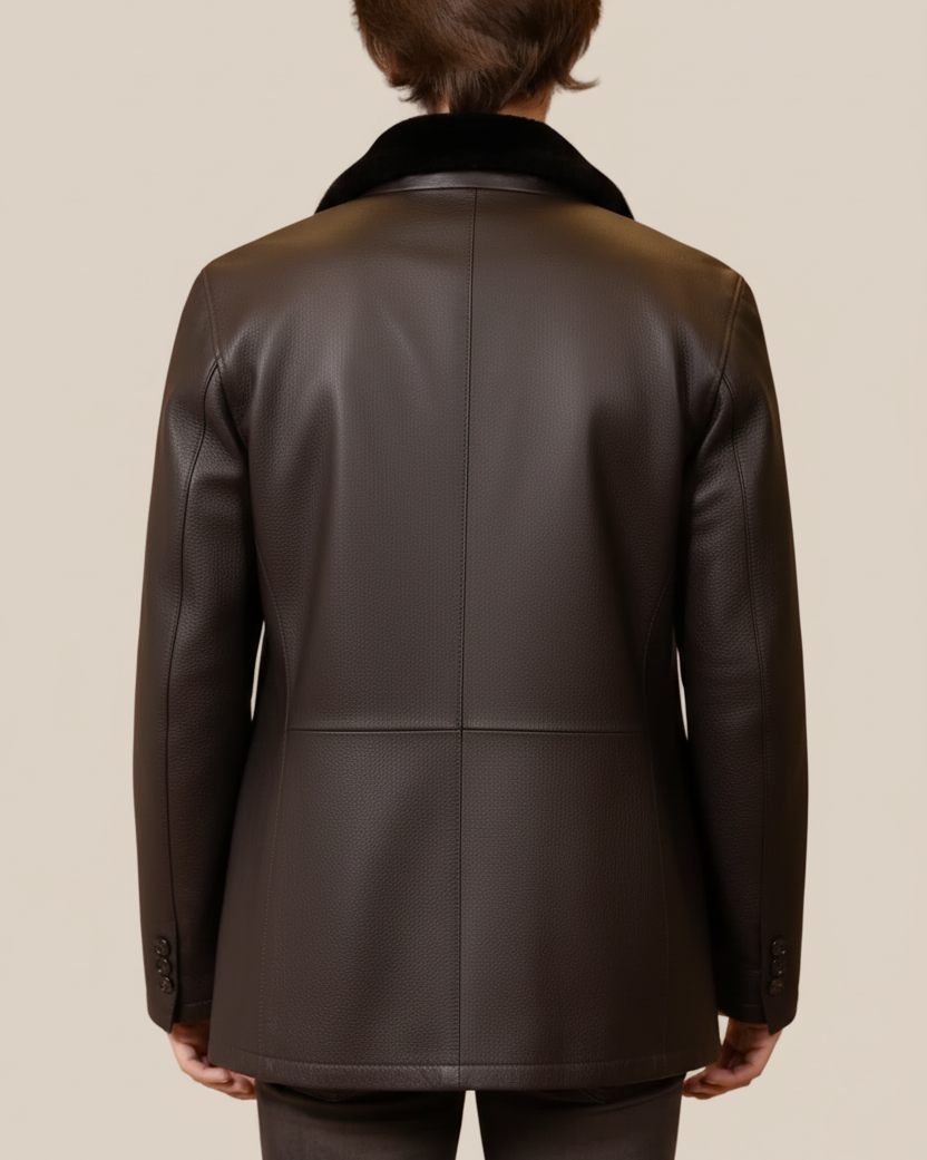 Person wearing a dark brown leather jacket on a beige background