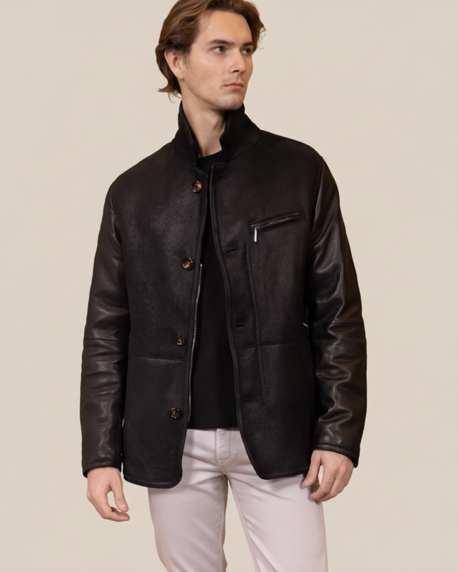 Man wearing a black leather jacket against a brown background