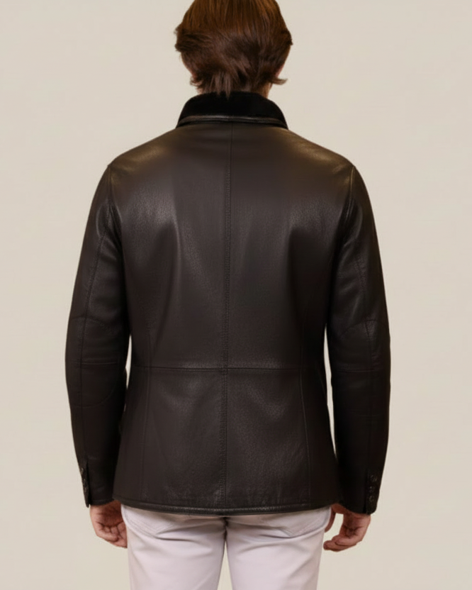 Person wearing a black leather jacket on a brown background
