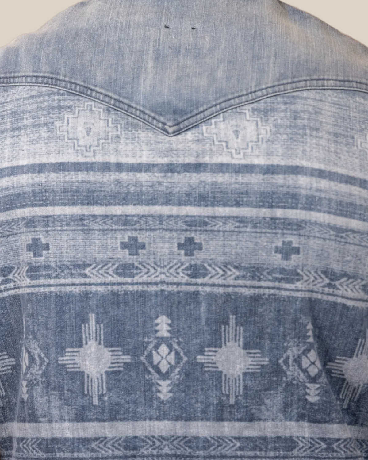 Blue denim shirt with geometric pattern on a white background