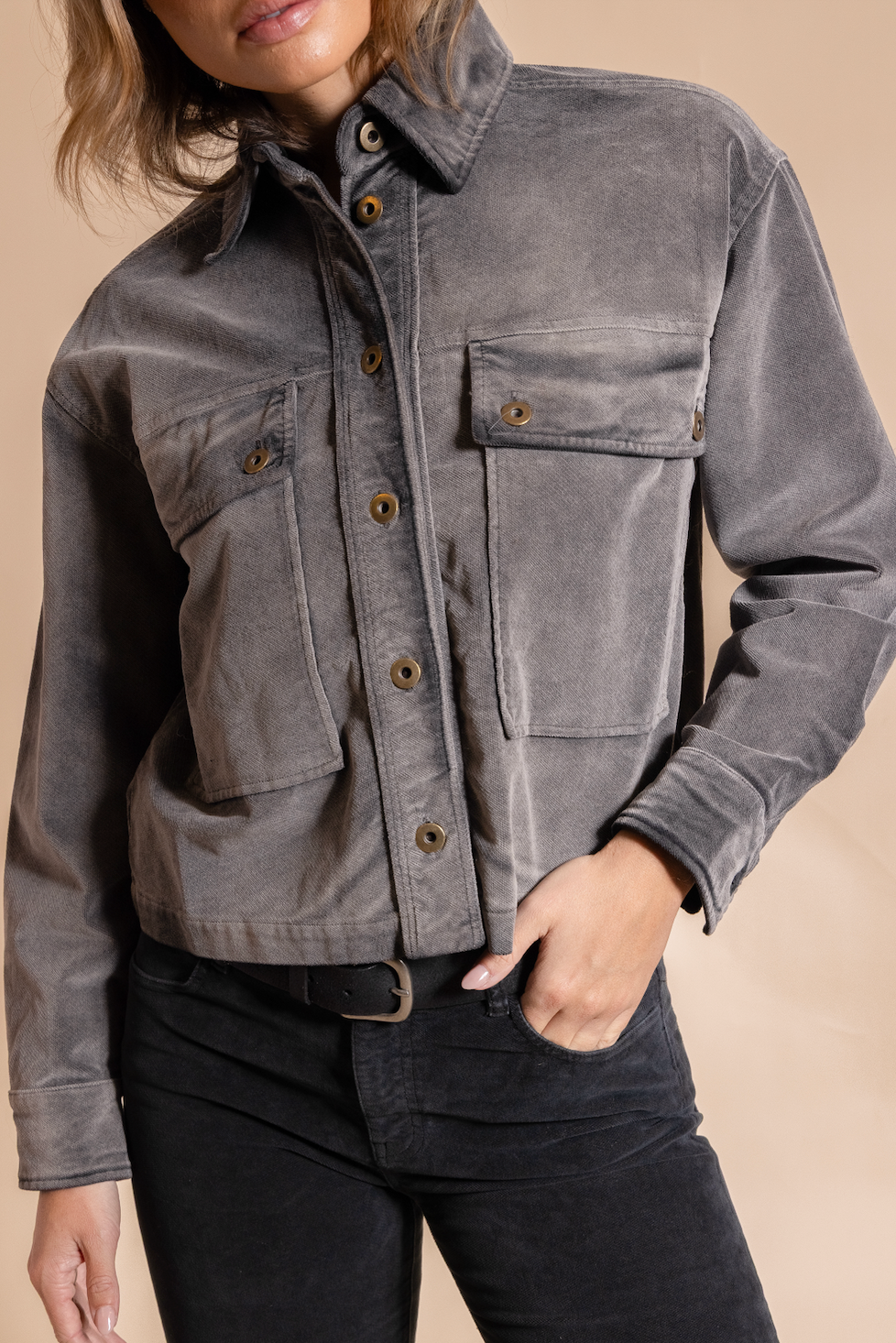Gray jacket worn by a person on a beige background