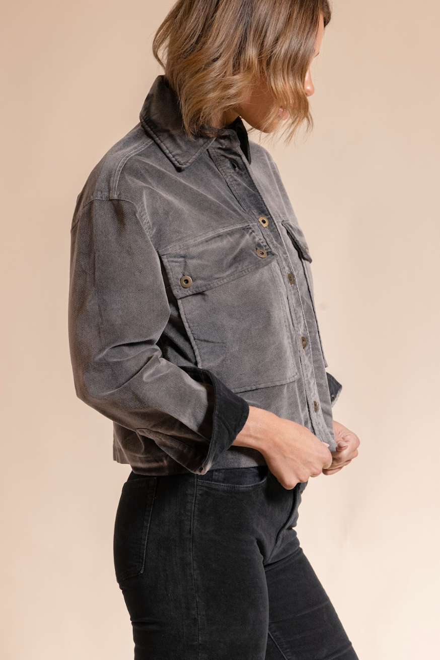 Person wearing a gray jacket on a beige background