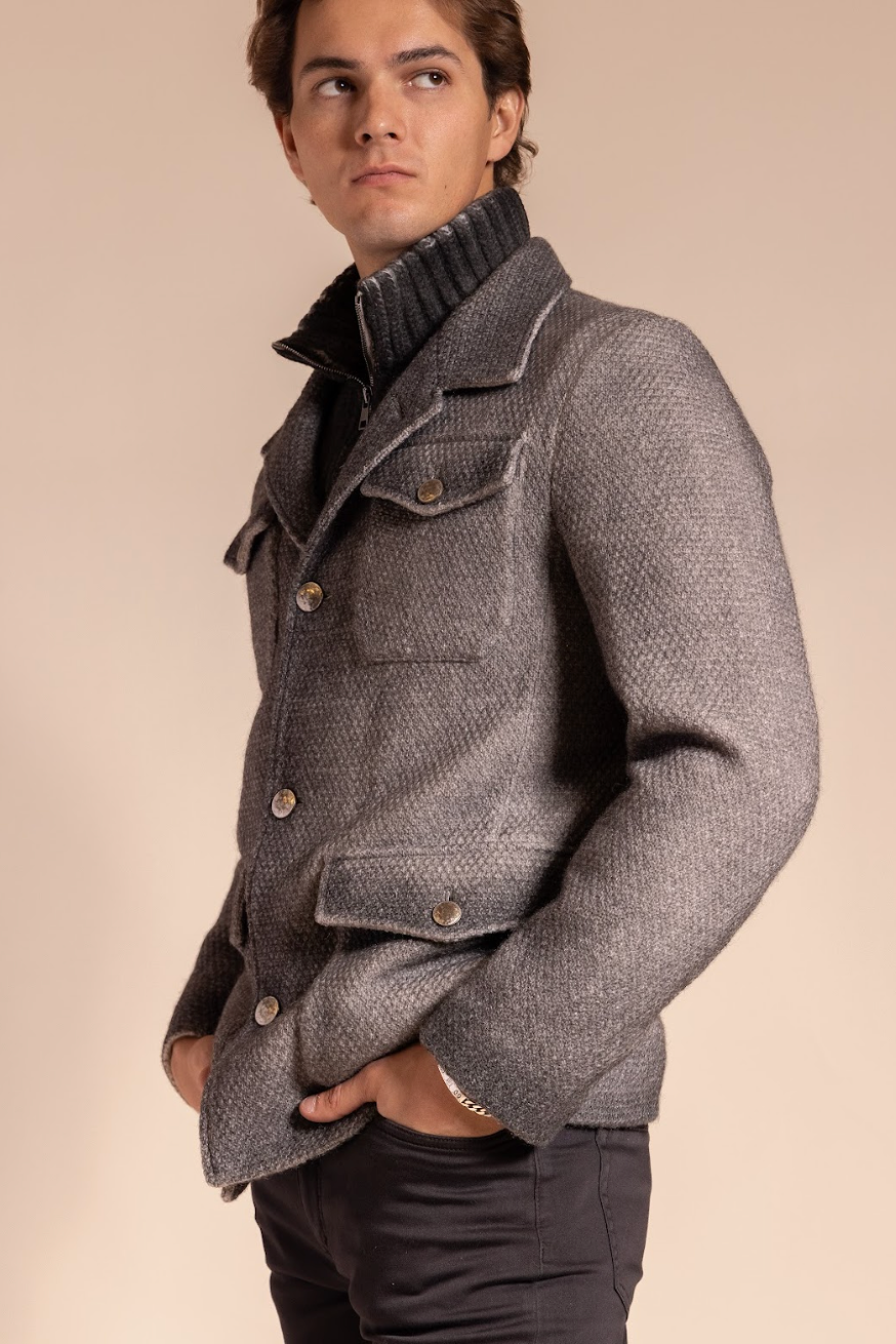 Man wearing a gray textured jacket against a beige background