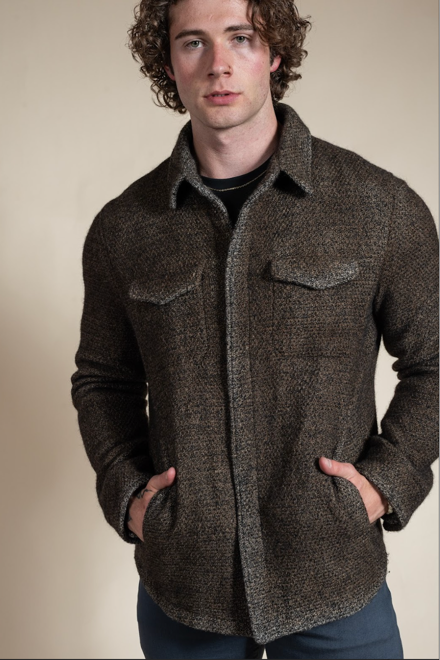 Man wearing a brown textured jacket against a beige background