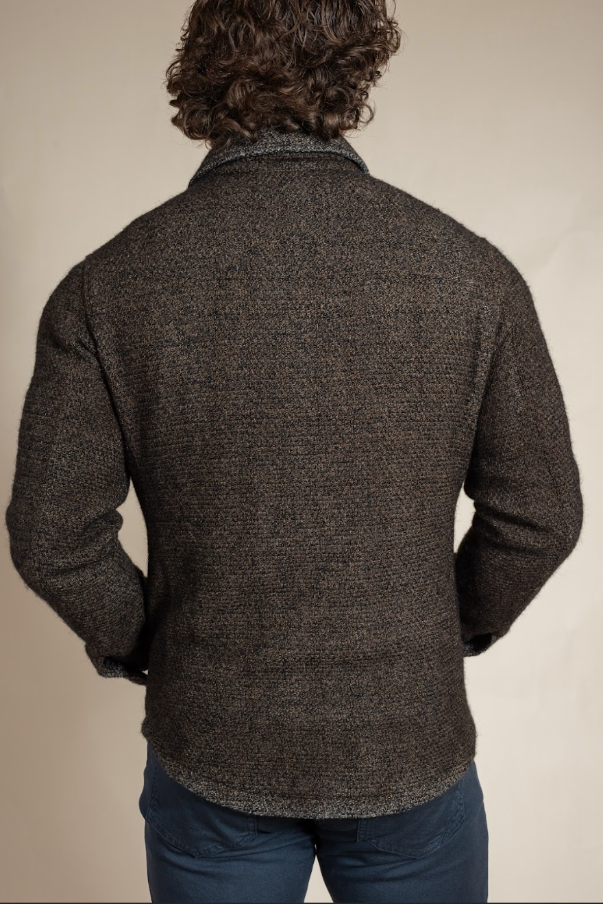 Man wearing a dark brown textured jacket on a beige background