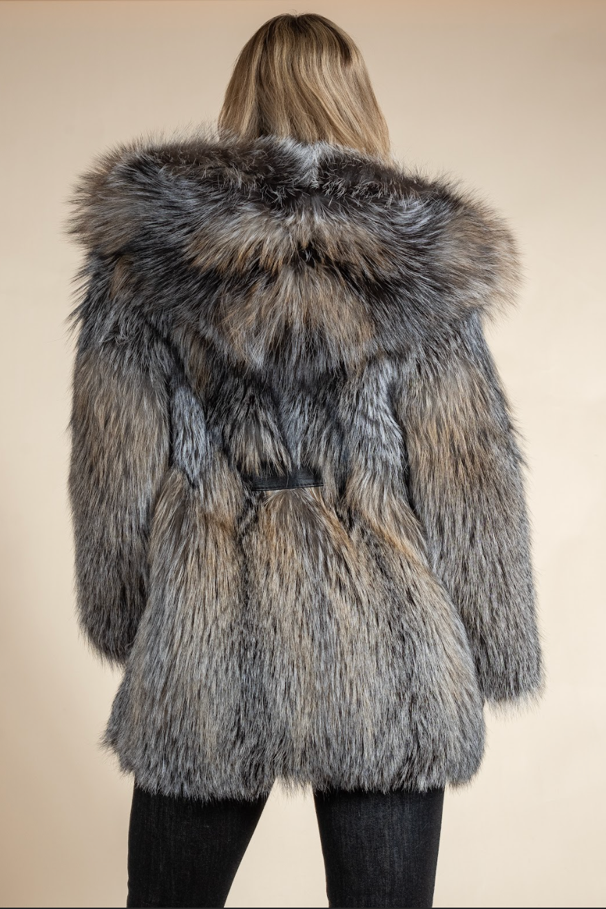 Person wearing a fur coat with a neutral background
