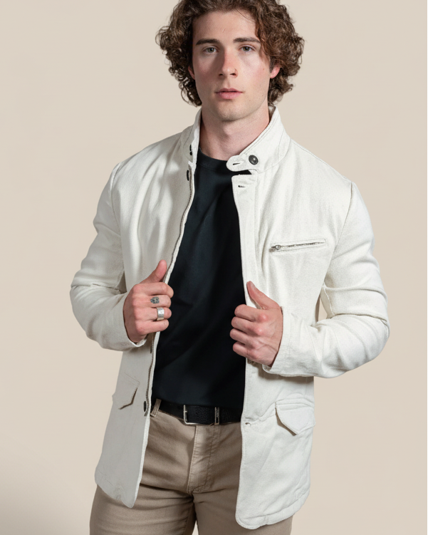 Man wearing a white jacket over a black shirt on a beige background