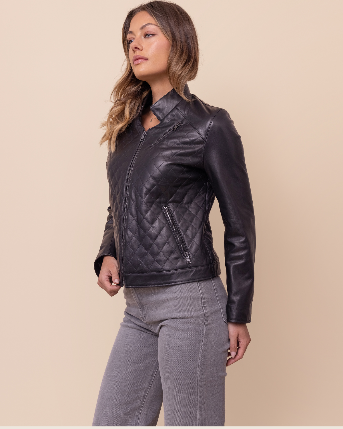 Woman wearing HYDE Carbon Noir quilted lambskin jacket — tonal black body and Napa sleeves, tailored fit, handcrafted in USA