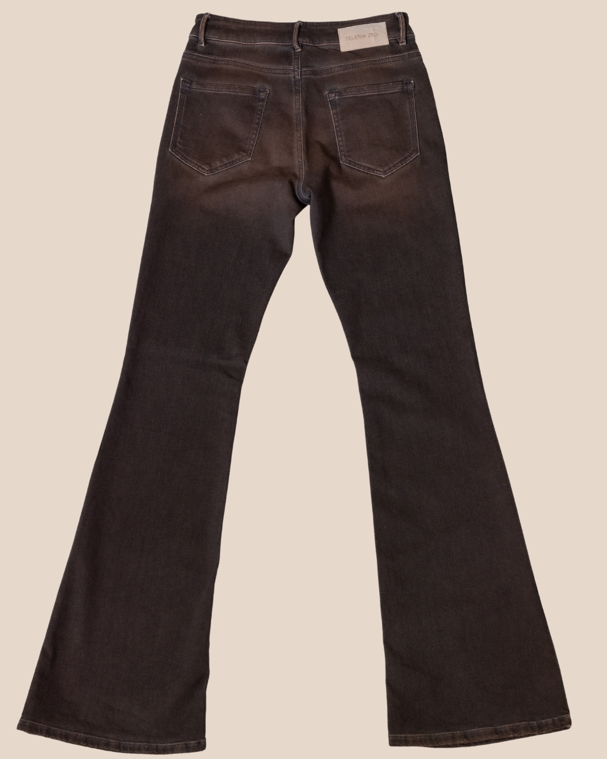 Desert color  bell-bottom jeans on a beige background