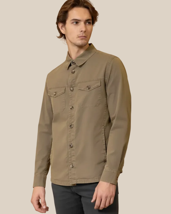Man wearing a brown button-up shirt against a beige background