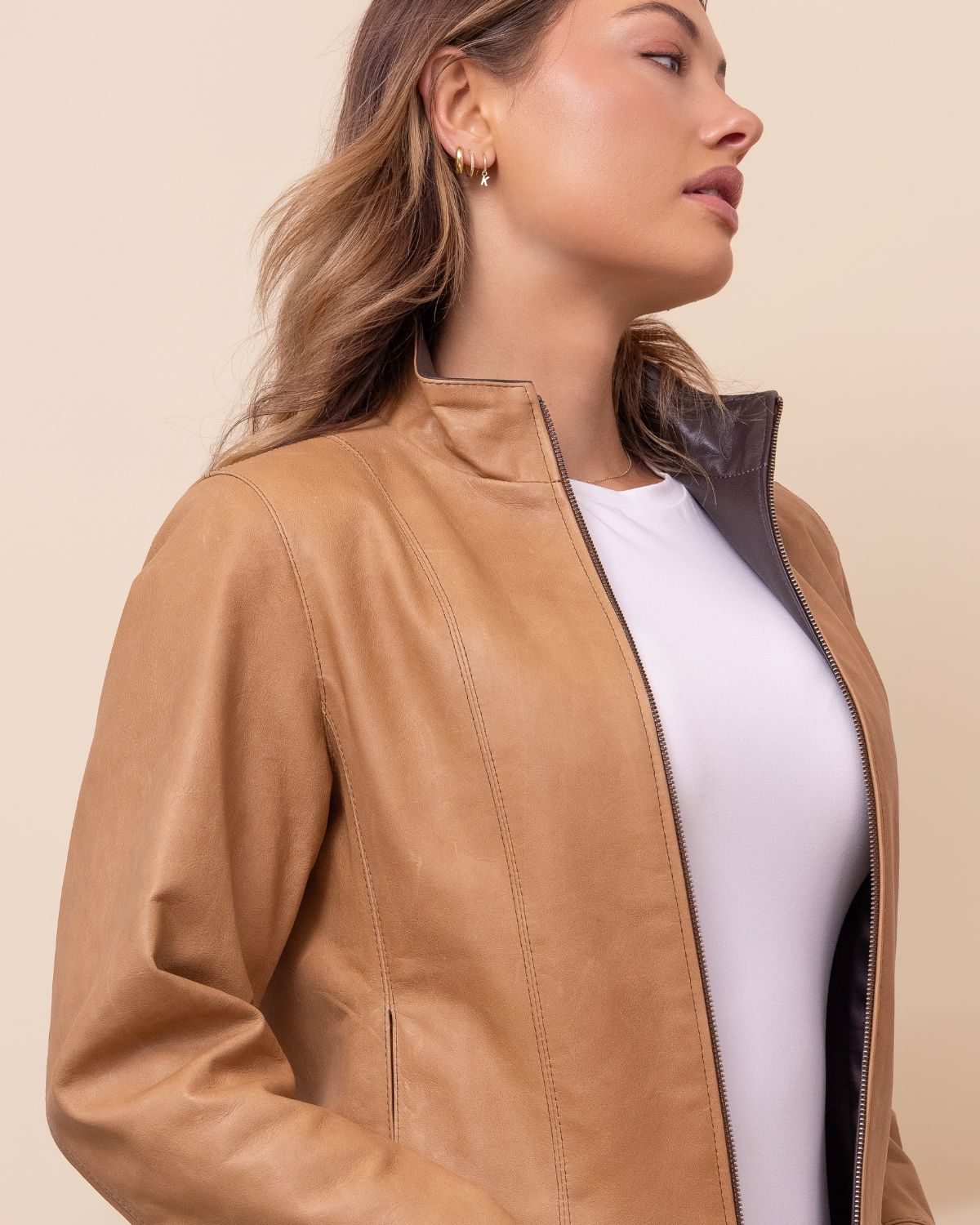 Woman wearing HYDE Sienna Sand Rustic waxy lambskin jacket — warm sand tone, tailored fit, handcrafted in Los Angeles