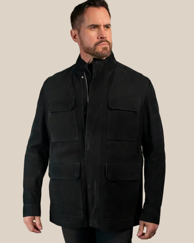 Man wearing a black jacket with multiple pockets on a beige background