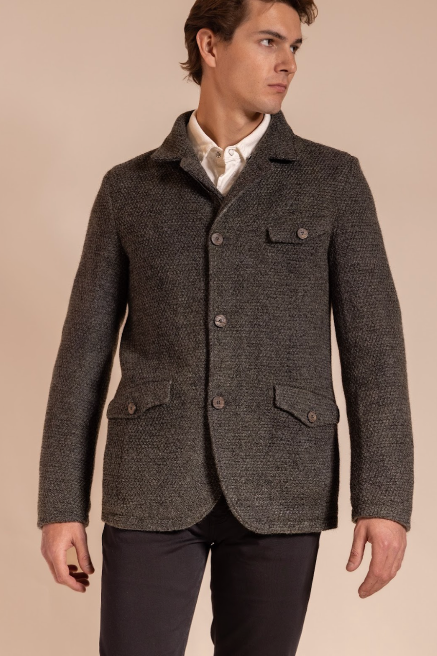 Man wearing a gray textured jacket on a beige background