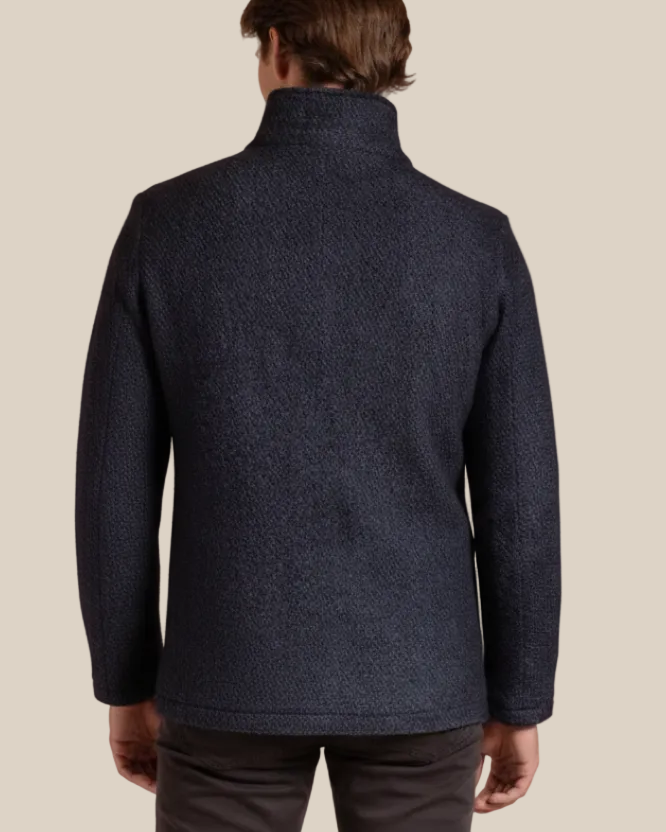 Man wearing a dark blue textured jacket on a beige background