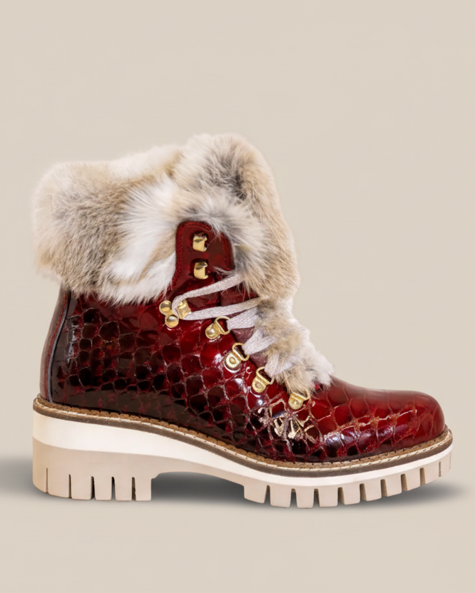 Red winter boot with fur trim on a white background