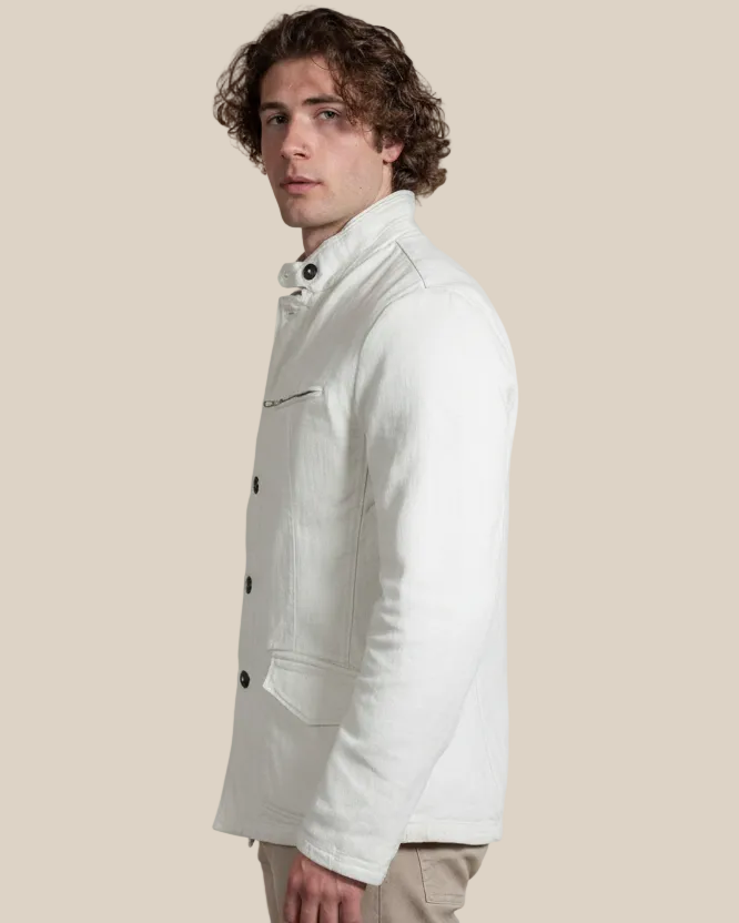 Man wearing a white jacket against a beige background
