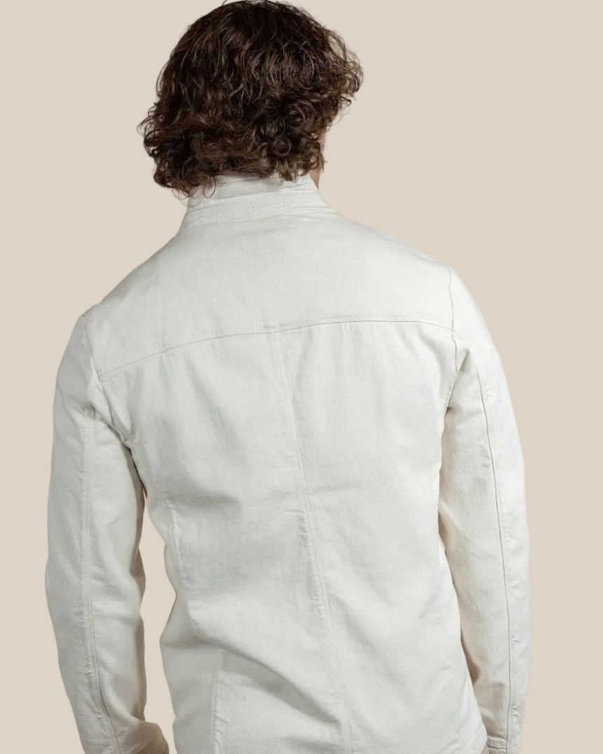 Person wearing a light-colored jacket on a beige background