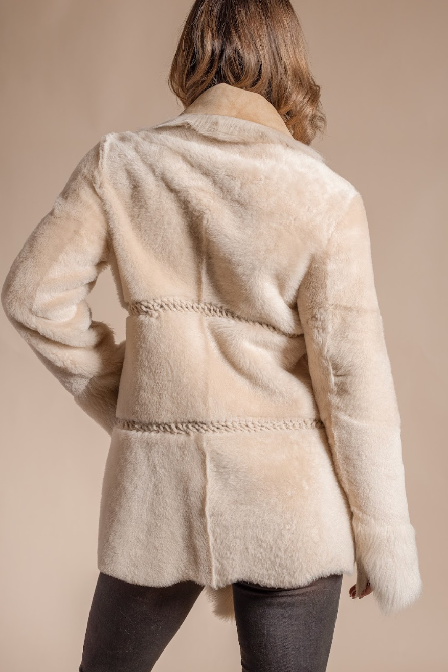 Beige coat worn by a person on a beige background