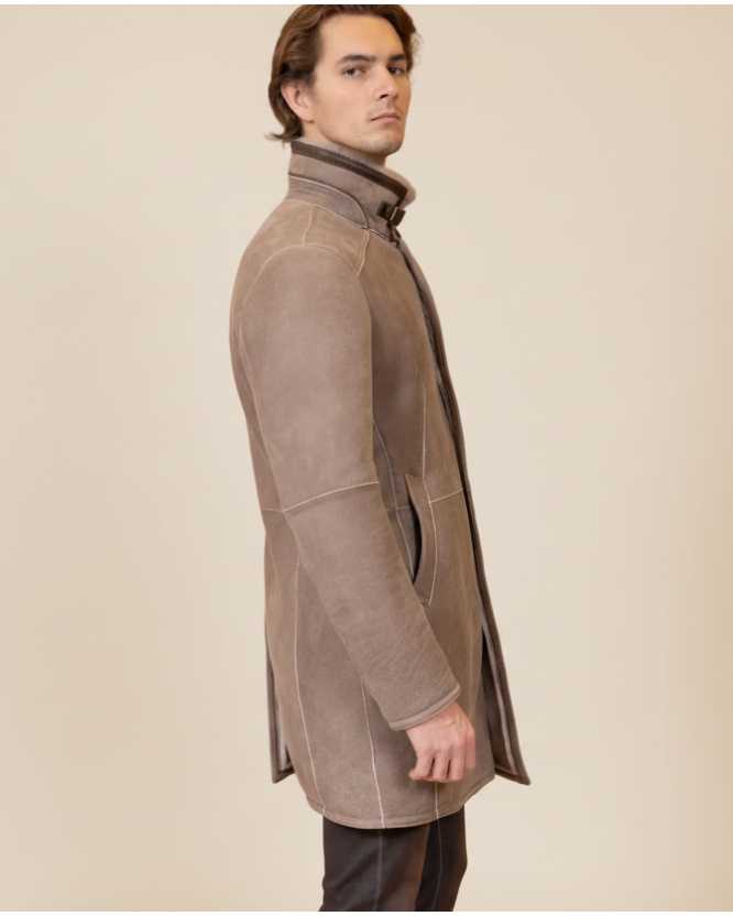 Man wearing a brown suede coat against a beige background