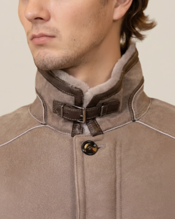 Close-up of a brown coat with a fur-lined collar on a beige background