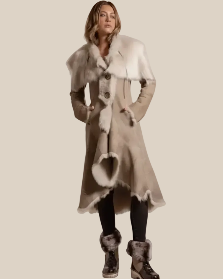 Woman wearing a long, patterned coat with fur trim on a beige background