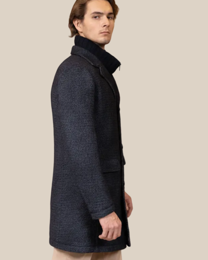 Man wearing a dark coat on a beige background