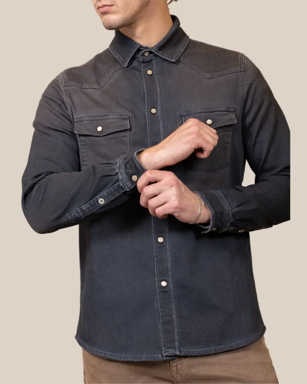 Man wearing a dark denim shirt on a beige background