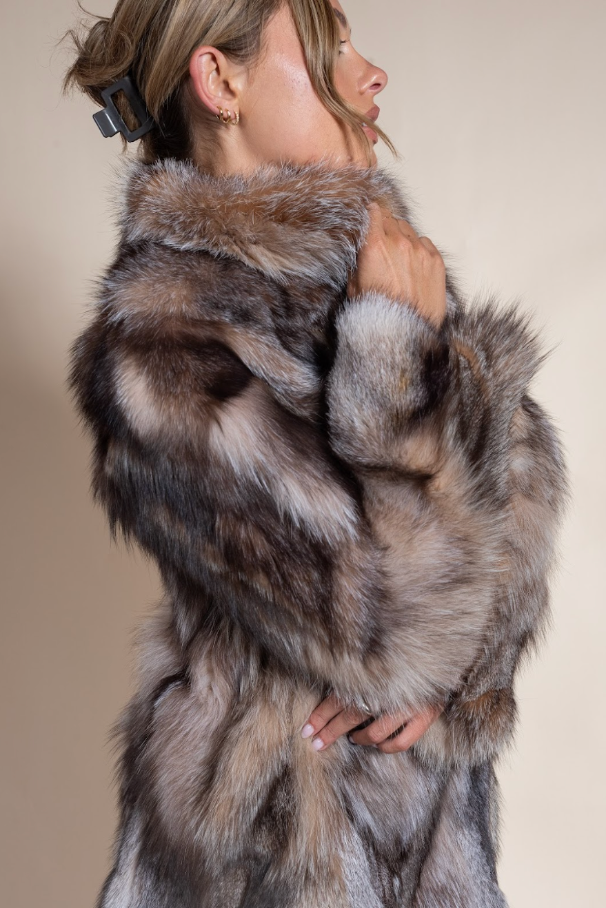 Person wearing a fur coat with a neutral background