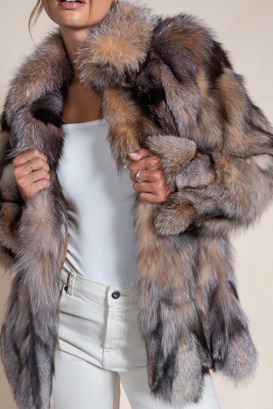 Person wearing a fur coat with a neutral background