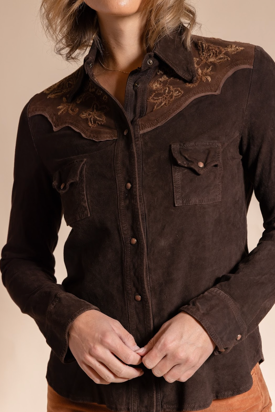 Brown embroidered shirt worn by a person on a beige background