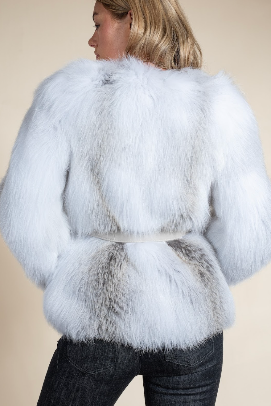 White fur coat worn by a person on a beige background