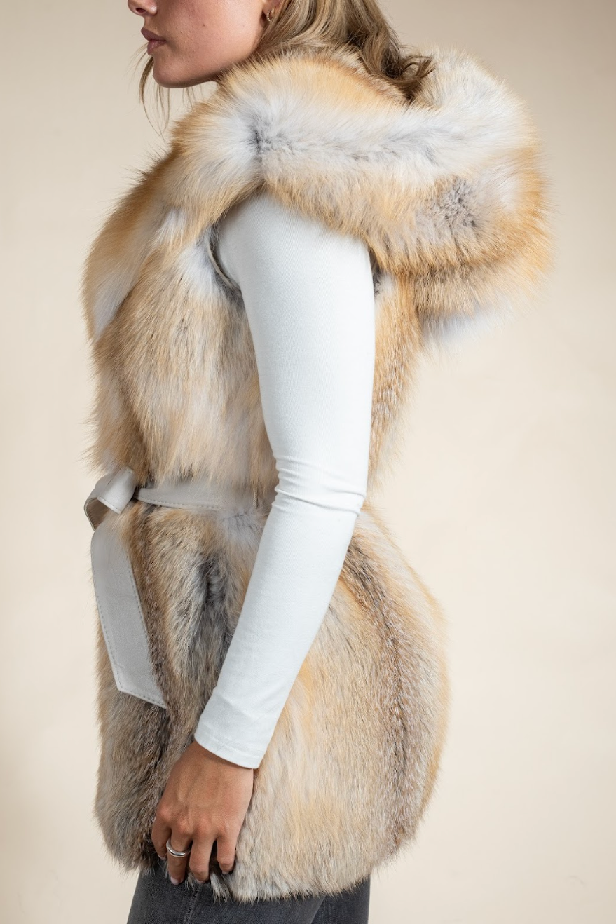 Person wearing a fur vest with a neutral background