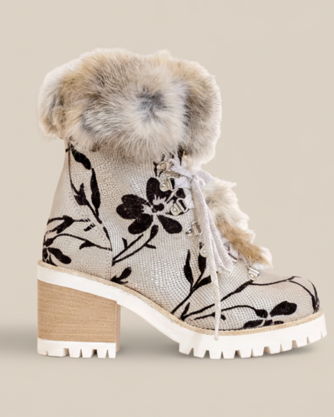 White boot with black floral pattern and fur trim on a white background